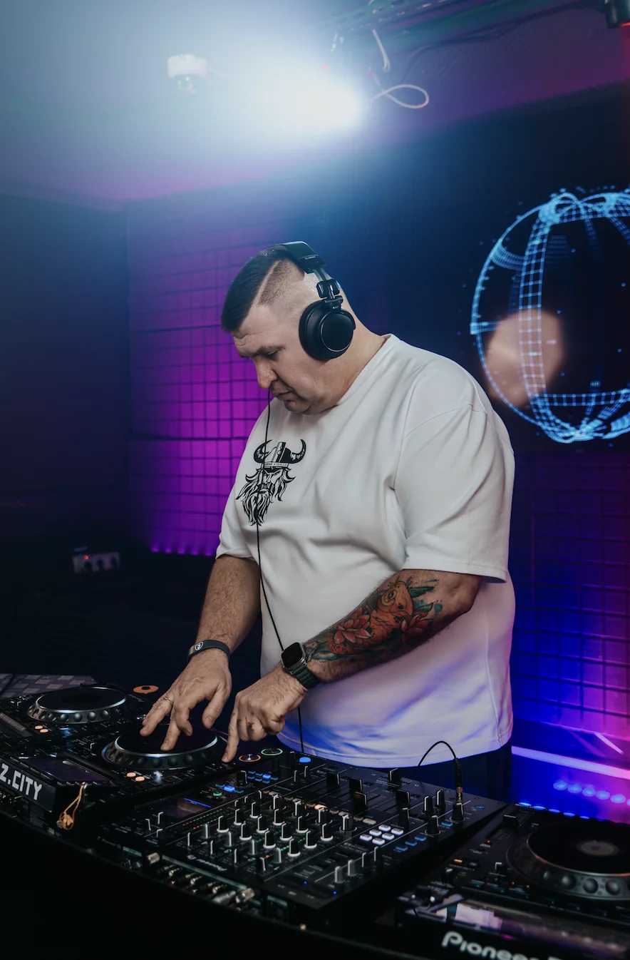Ведущий и DJ Alex XXL за диджейским пультом с микрофоном
