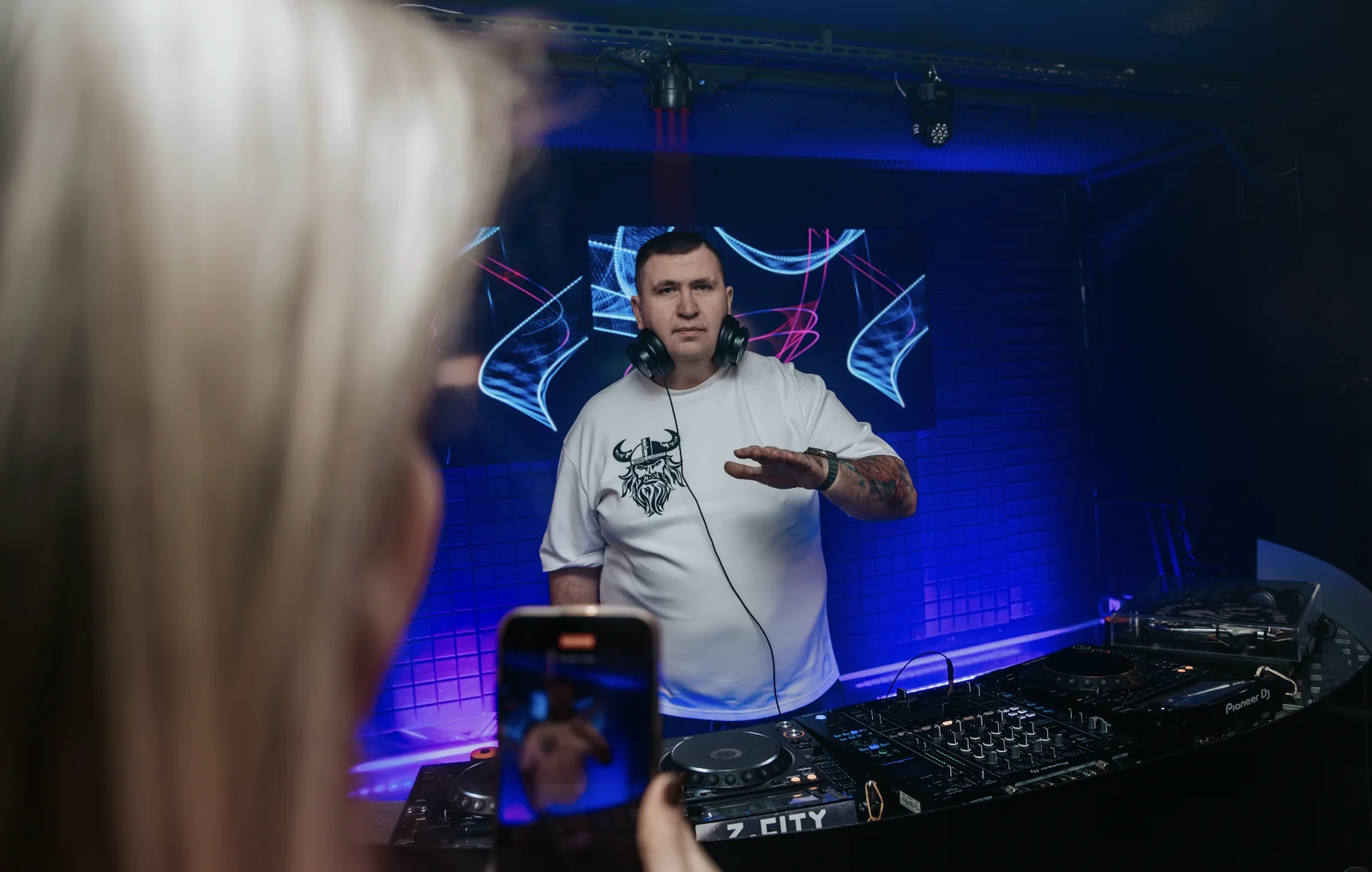 DJ Alex XXL за пультом с микрофоном на мероприятии